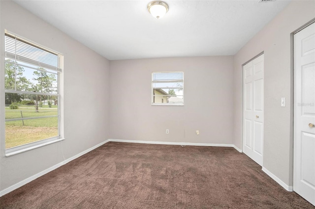 unfurnished bedroom with multiple windows and carpet floors