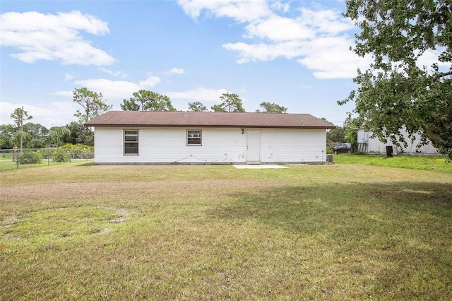 rear view of property featuring a lawn