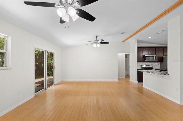 unfurnished living room featuring lofted ceiling, light hardwood / wood-style floors, and ceiling fan