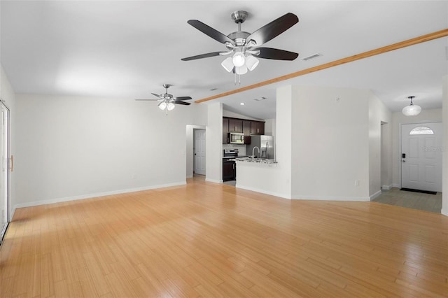 unfurnished living room featuring ceiling fan, sink, light wood-type flooring, and vaulted ceiling