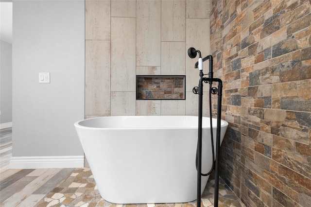 bathroom with a tub and hardwood / wood-style floors