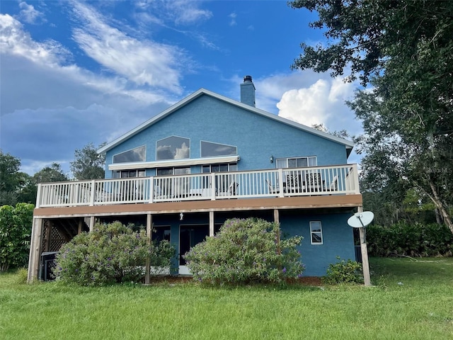 rear view of house with a wooden deck and a yard