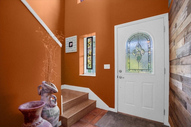 tiled foyer entrance featuring wood walls