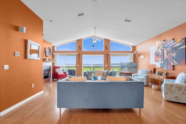 living room featuring high vaulted ceiling, light wood-type flooring, and ceiling fan