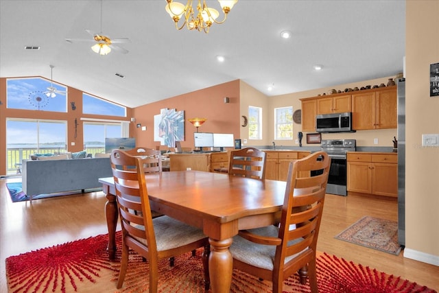 dining room featuring sink, ceiling fan with notable chandelier, light hardwood / wood-style floors, and high vaulted ceiling