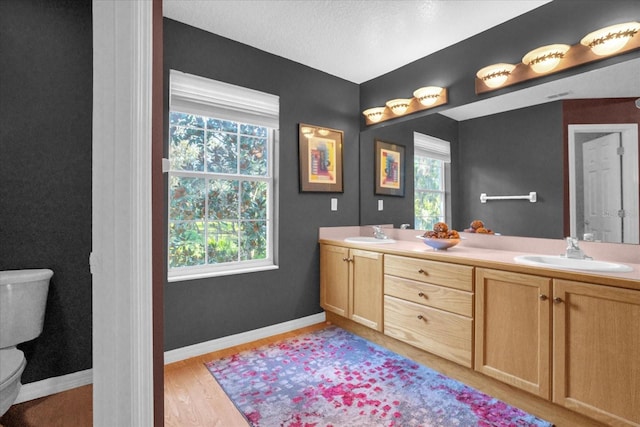 bathroom with vanity, hardwood / wood-style floors, toilet, and a textured ceiling