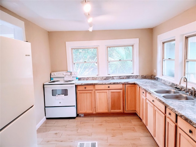 kitchen featuring sink, white appliances, and light brown cabinets