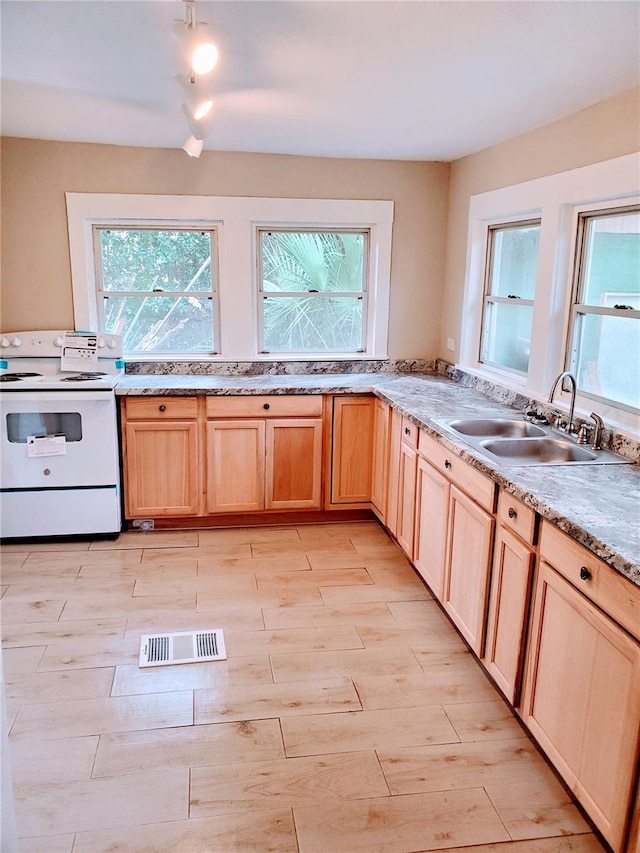 kitchen featuring sink, white range with electric cooktop, and light brown cabinets