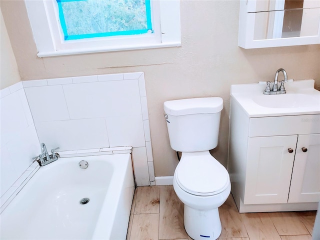 bathroom featuring toilet, a bath, and vanity