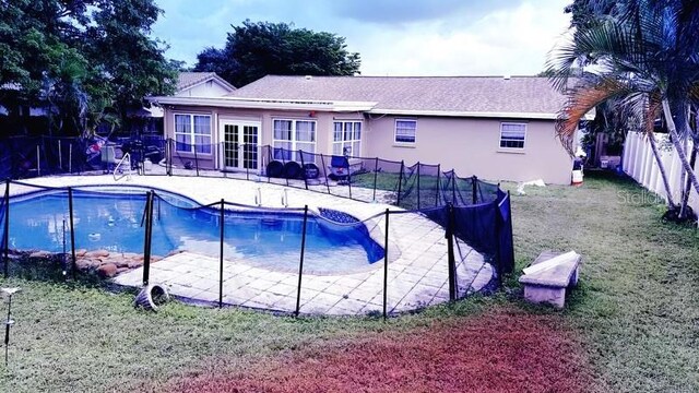 view of swimming pool featuring a patio area and a yard