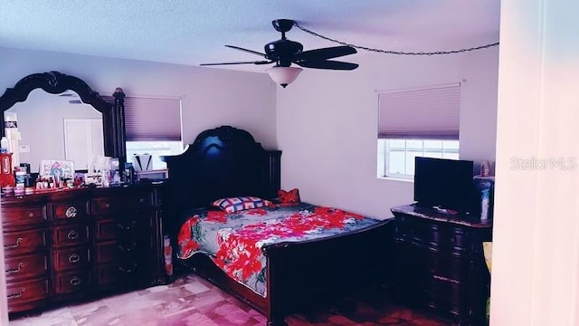 bedroom featuring ceiling fan and a textured ceiling