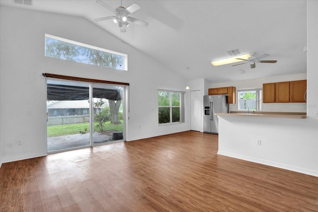 unfurnished living room with ceiling fan, high vaulted ceiling, sink, and dark wood-type flooring