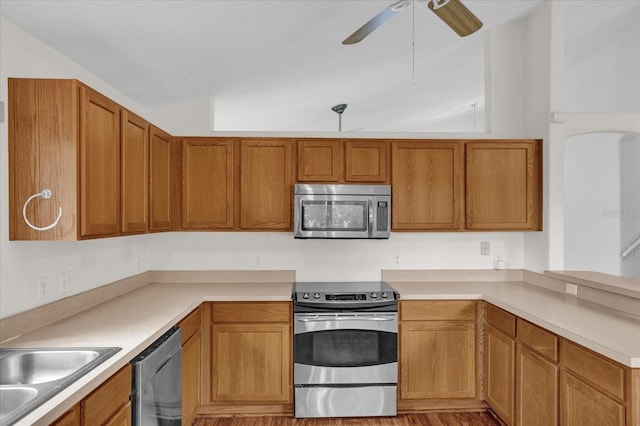 kitchen with sink, vaulted ceiling, stainless steel appliances, and ceiling fan