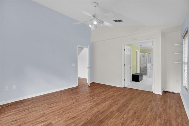 unfurnished bedroom featuring ceiling fan, light wood-type flooring, connected bathroom, and lofted ceiling