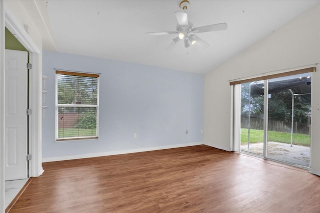 spare room featuring ceiling fan, vaulted ceiling, wood-type flooring, and a healthy amount of sunlight