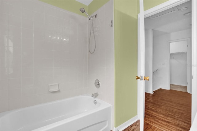 bathroom with tiled shower / bath combo and wood-type flooring