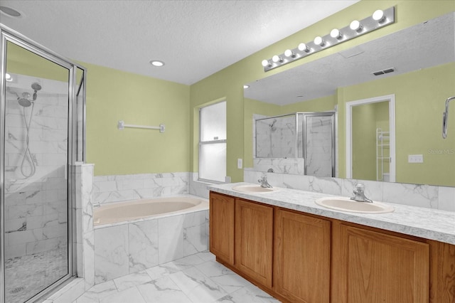 bathroom featuring vanity, shower with separate bathtub, and a textured ceiling