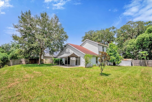 back of property featuring a lawn and a patio area