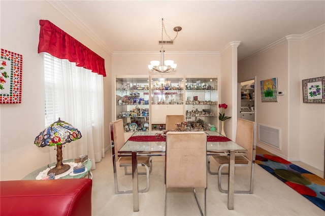 dining room with a chandelier, ornamental molding, and carpet flooring