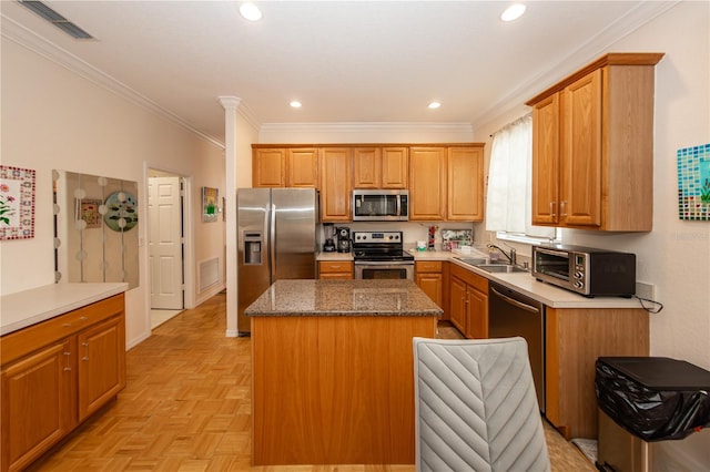 kitchen with light parquet flooring, sink, dark stone countertops, a center island, and stainless steel appliances