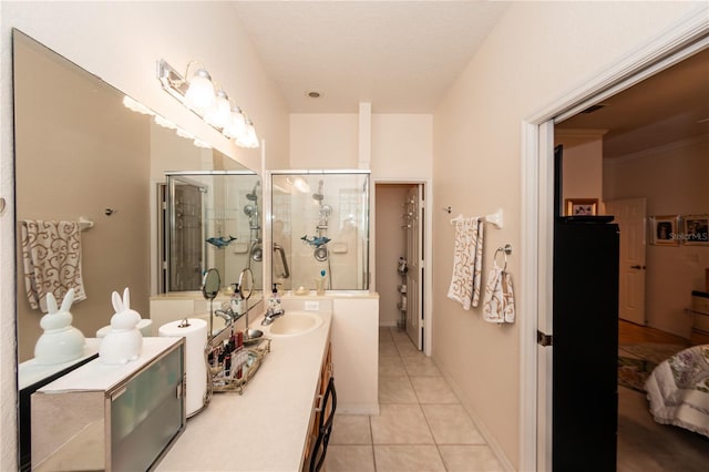 bathroom with tile patterned flooring, vanity, and walk in shower