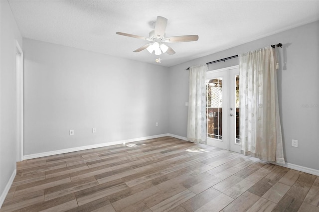 spare room featuring french doors, baseboards, and wood finished floors