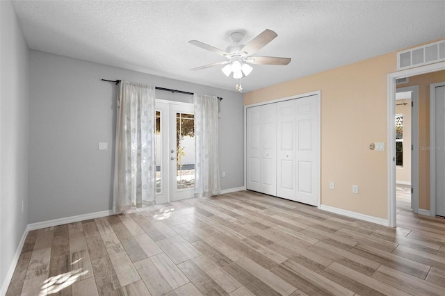 unfurnished bedroom with a closet, visible vents, wood finished floors, and french doors