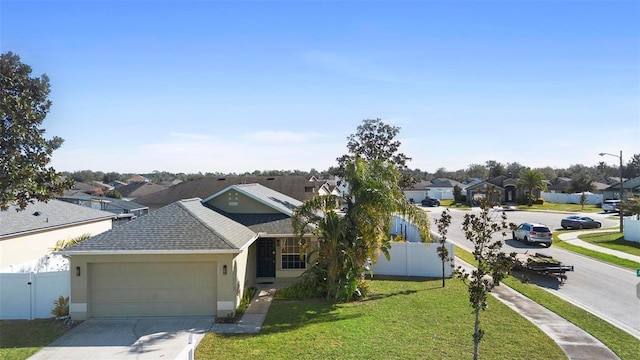 ranch-style home featuring fence, driveway, a residential view, stucco siding, and a front lawn