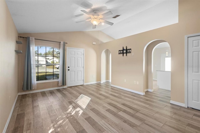 unfurnished room featuring a ceiling fan, light wood-type flooring, visible vents, and lofted ceiling