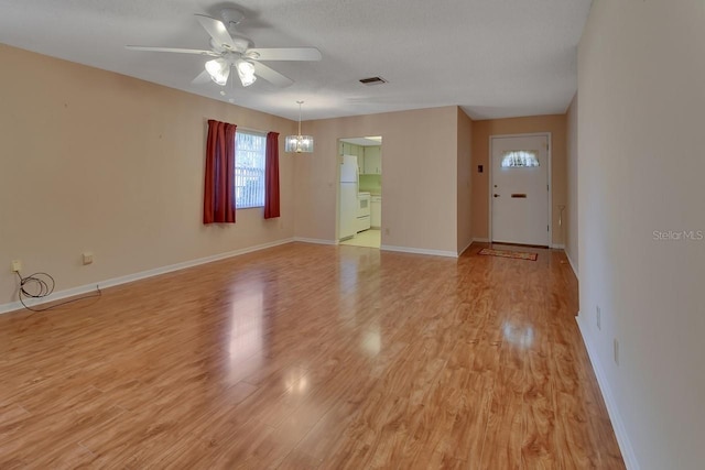 unfurnished room featuring ceiling fan with notable chandelier and light hardwood / wood-style floors