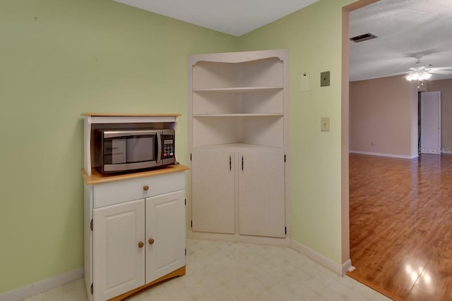 unfurnished living room with light wood-type flooring and ceiling fan