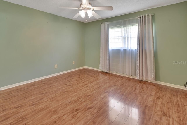 spare room featuring hardwood / wood-style floors, ceiling fan, and a textured ceiling