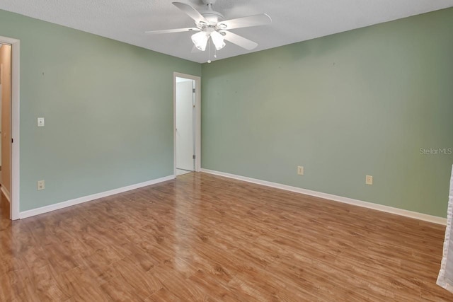 spare room with light hardwood / wood-style floors, ceiling fan, and a textured ceiling