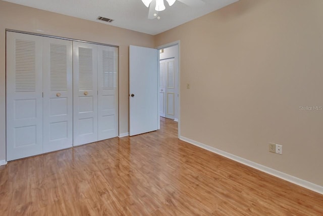 unfurnished bedroom with ceiling fan, light wood-type flooring, and a closet