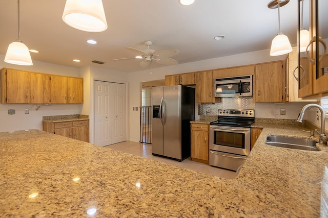 kitchen featuring ceiling fan, hanging light fixtures, light tile patterned floors, sink, and appliances with stainless steel finishes