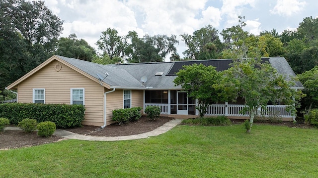 view of front of property with a sunroom and a front yard