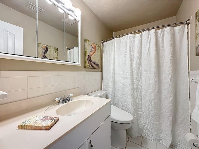 bathroom featuring curtained shower, tile patterned floors, toilet, tile walls, and vanity