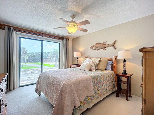 bedroom with ceiling fan, light carpet, and a textured ceiling