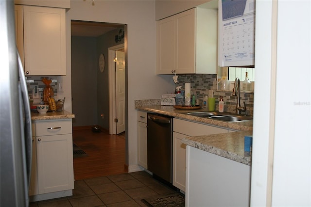 kitchen featuring appliances with stainless steel finishes, decorative backsplash, white cabinetry, dark wood-type flooring, and sink