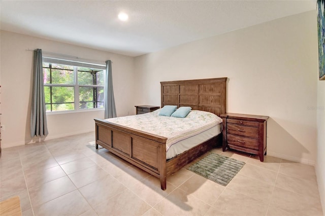 bedroom featuring light tile patterned flooring and baseboards