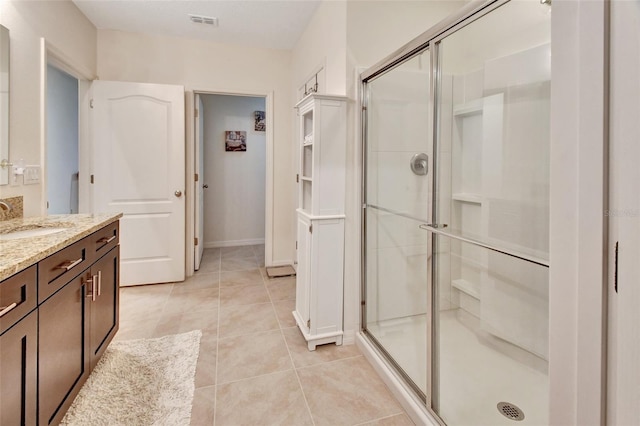 bathroom featuring vanity, a shower stall, visible vents, and tile patterned floors