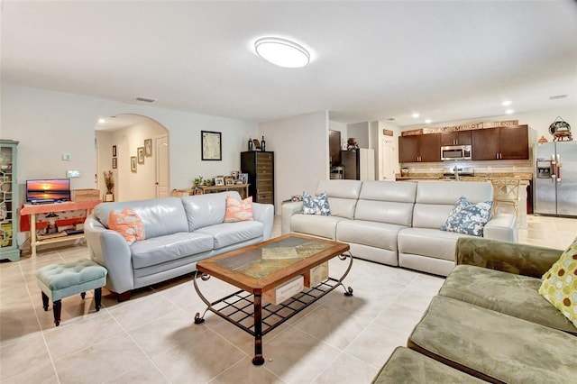 living room featuring arched walkways, visible vents, recessed lighting, and light tile patterned floors