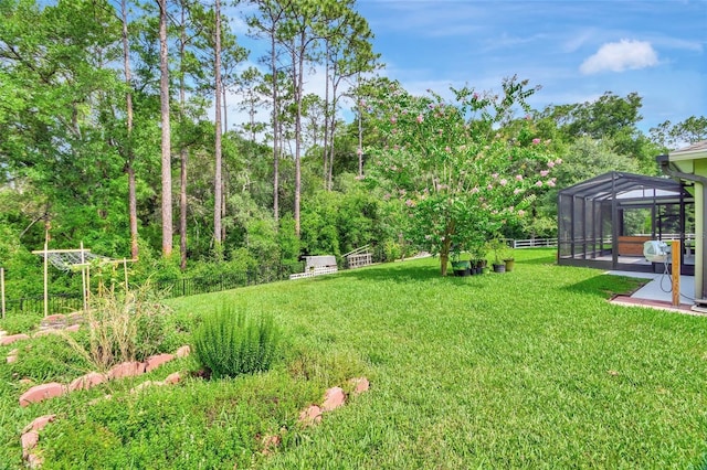 view of yard featuring a lanai, a patio area, and fence