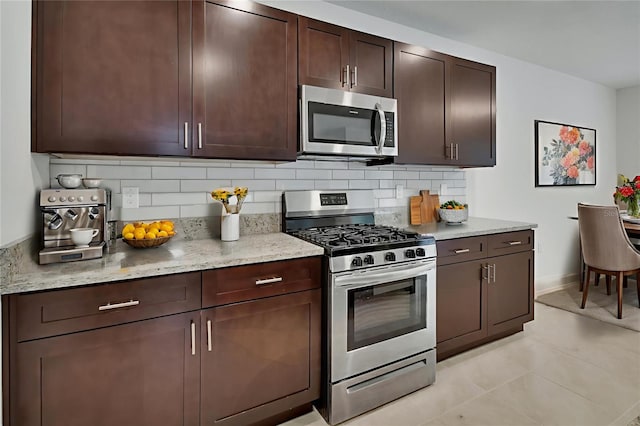 317 Nowell Loop, Deland, FL 32724 - kitchen with stainless steel appliances, decorative backsplash, dark brown cabinetry, and light stone countertops