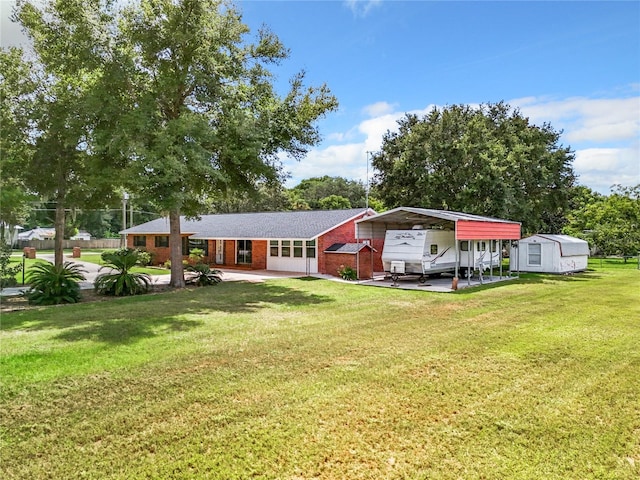view of front of house with brick siding, a front yard, driveway, and a carport