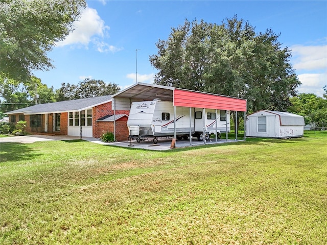 view of front of house with a front yard, a shed, and a carport