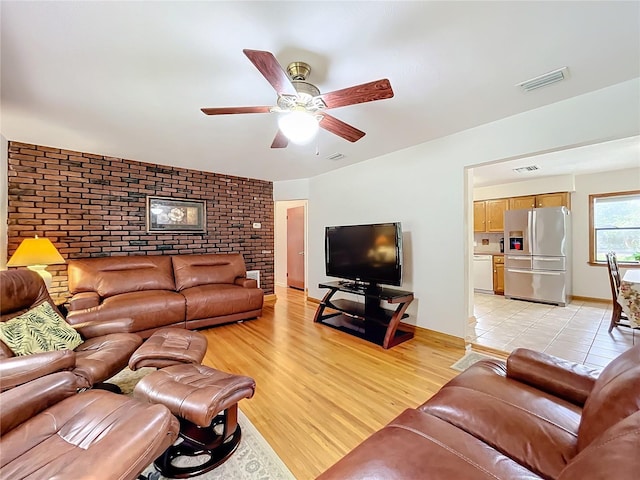 tiled living room with brick wall and ceiling fan