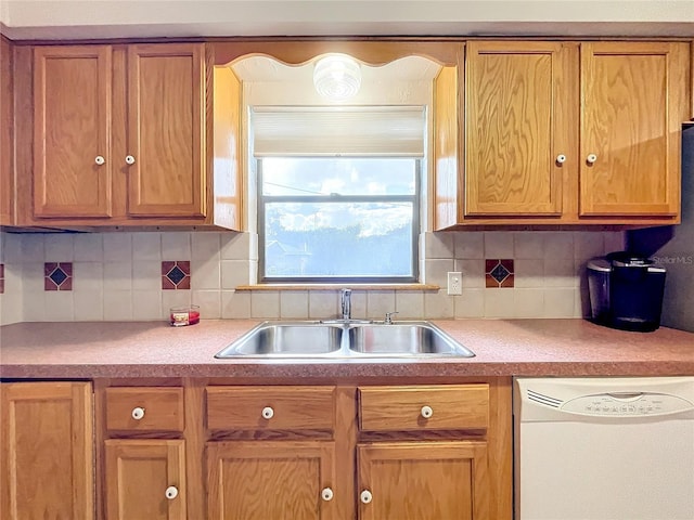 kitchen featuring backsplash, dishwasher, and sink