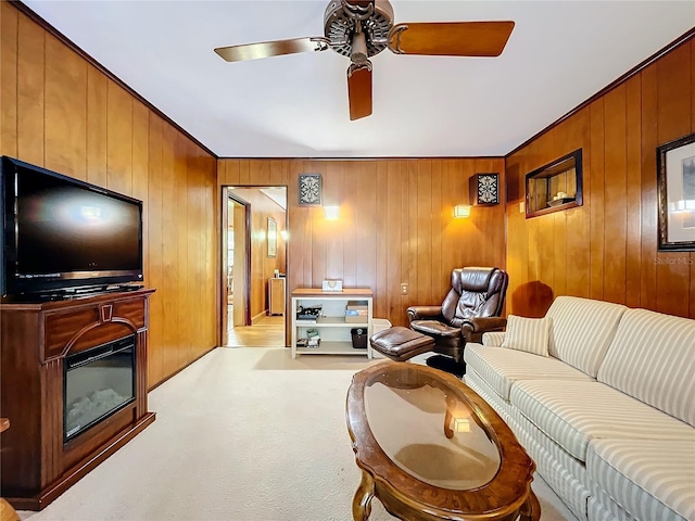 living room featuring ceiling fan, light colored carpet, and wooden walls