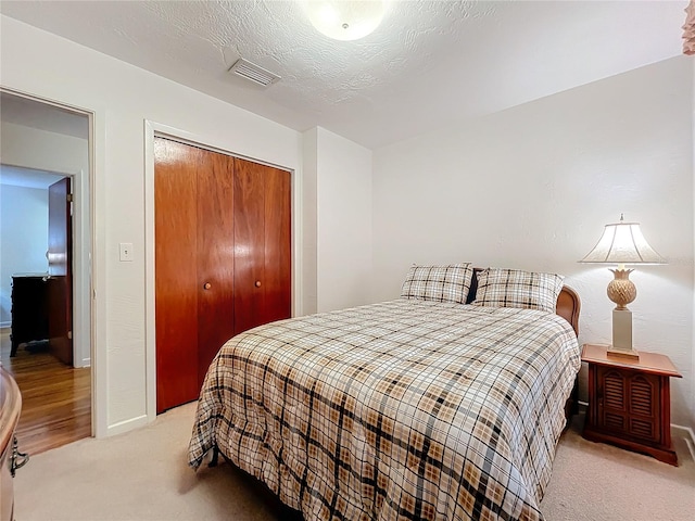 carpeted bedroom featuring a closet and a textured ceiling